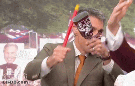 Man In Suit And Tie Holding Texas Tech Cup GIF