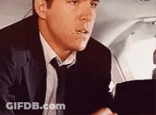 Man In Suit And Tie In Airplane Back Seat GIF