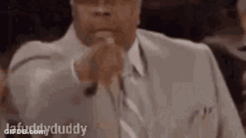 Man In Suit And Tie In Courtroom With Folded Hands GIF