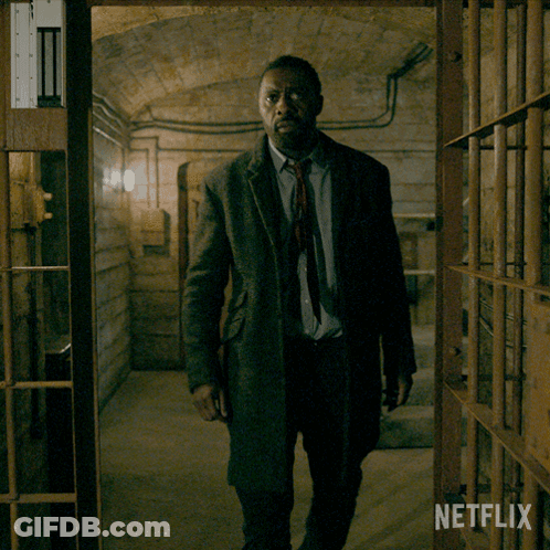 Man In Suit And Tie In Dark Room With Netflix Logo GIF