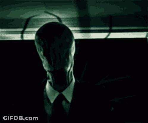 Man In Suit And Tie In Dark With Shadow GIF