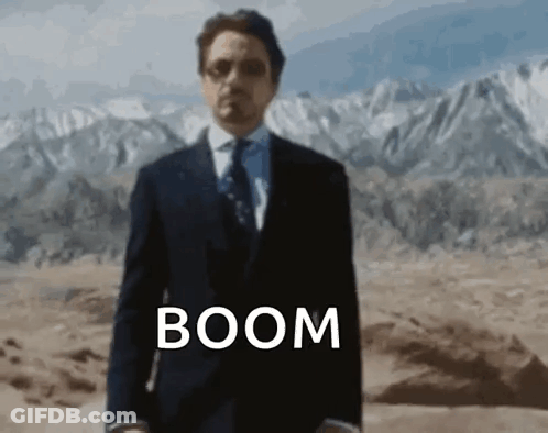 Man In Suit And Tie In Desert With Word Boom GIF