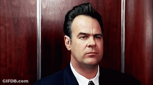 Man In Suit And Tie In Elevator Looking At Camera GIF