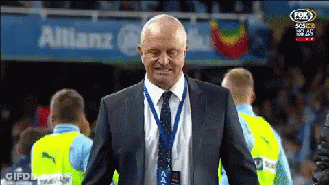 Man In Suit And Tie In Front Of Allianz Banner GIF