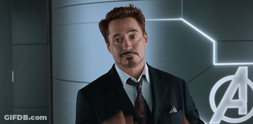 Man In Suit And Tie In Front Of Avengers Sign GIF