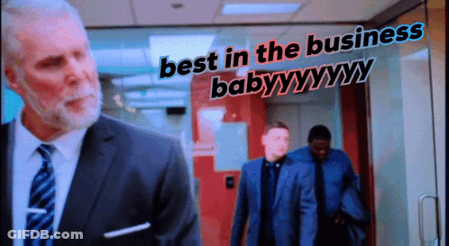 Man In Suit And Tie In Front Of Best In The Business Baby Sign GIF