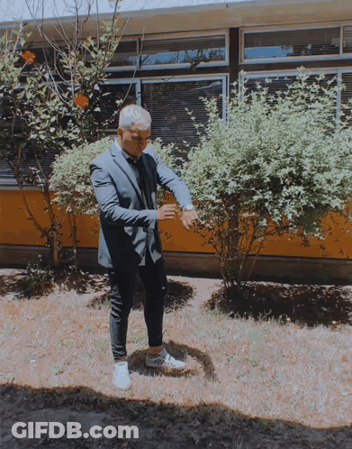 Man In Suit And Tie In Front Of Building GIF