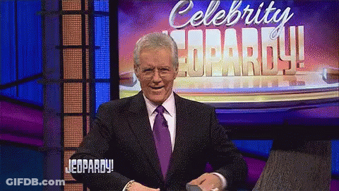 Man In Suit And Tie In Front Of Celebrity Jeopardy Sign GIF