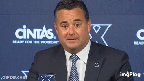 Man In Suit And Tie In Front Of Cintas Sign GIF