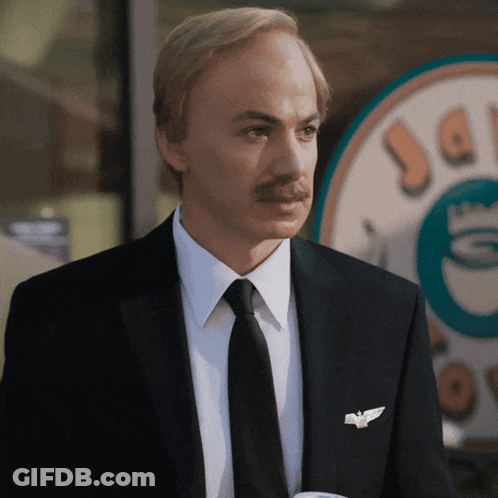 Man In Suit And Tie In Front Of Coffee Shop GIF