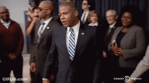 Man In Suit And Tie In Front Of Crowd Comedy Central Logo GIF