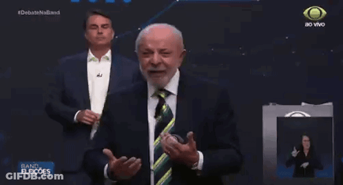 Man In Suit And Tie In Front Of Debate Screen GIF