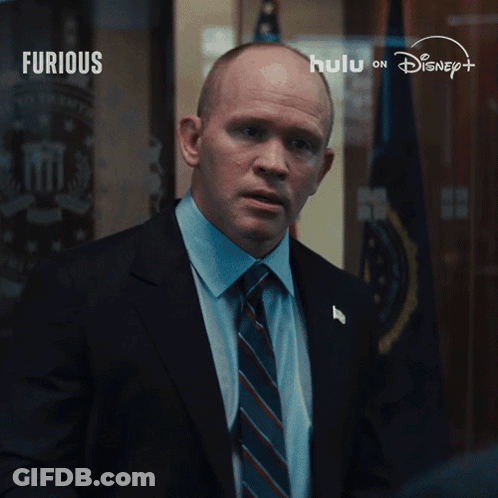 Man In Suit And Tie In Front Of Disney Logo GIF
