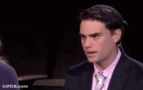 Man In Suit And Tie In Front Of Facts Sign GIF