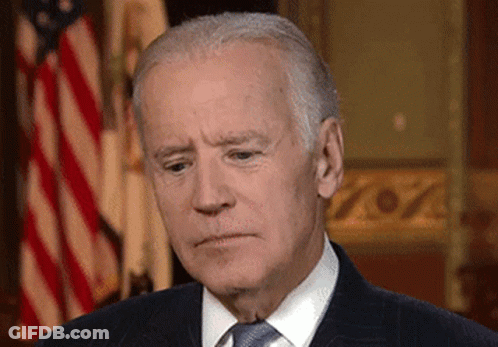 Man In Suit And Tie In Front Of Flag GIF