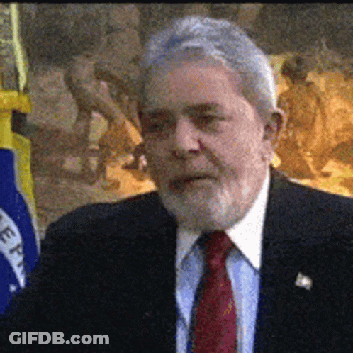 Man In Suit And Tie In Front Of Flag Saying Eee GIF