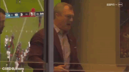 Man In Suit And Tie In Front Of Football Field GIF