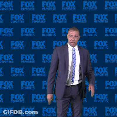 Man In Suit And Tie In Front Of Fox Deportes Background GIF