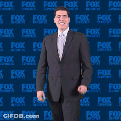 Man In Suit And Tie In Front Of Fox Deportes Background GIF