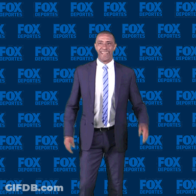 Man In Suit And Tie In Front Of Fox Deportes Background GIF