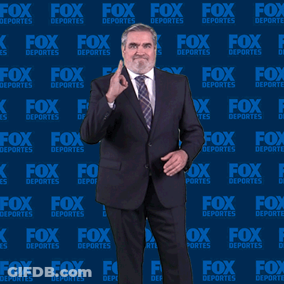 Man In Suit And Tie In Front Of Fox Deportes Background GIF