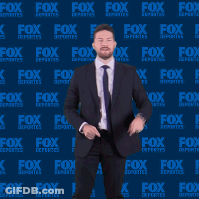 Man In Suit And Tie In Front Of Fox Deportes Background GIF