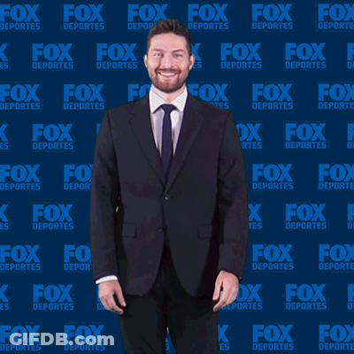 Man In Suit And Tie In Front Of Fox Deportes Background GIF