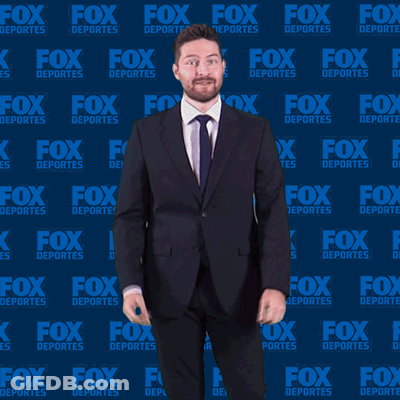 Man In Suit And Tie In Front Of Fox Deportes Background GIF