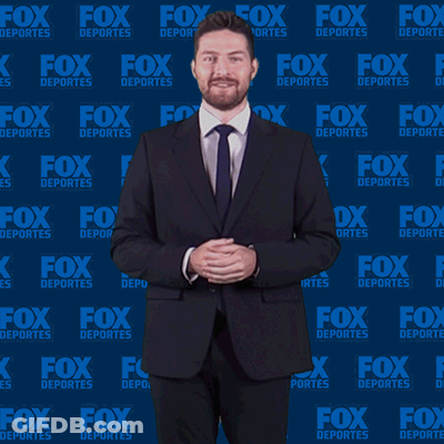 Man In Suit And Tie In Front Of Fox Deportes Background GIF