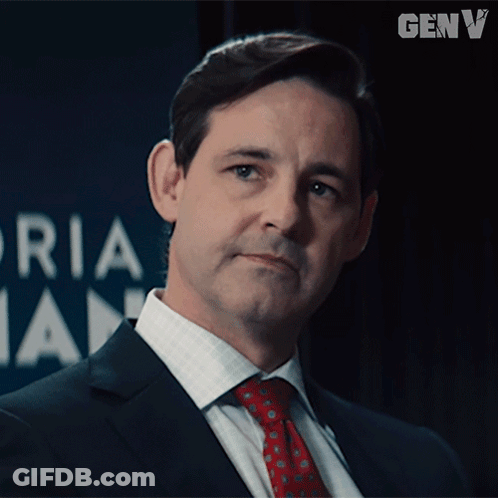 Man In Suit And Tie In Front Of Genv Logo GIF