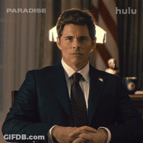 Man In Suit And Tie In Front Of Hulu Ad GIF