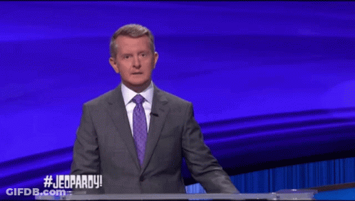 Man In Suit And Tie In Front Of Jeopardy Screen GIF