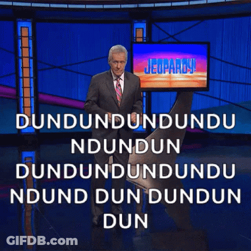 Man In Suit And Tie In Front Of Jeopardy Screen GIF
