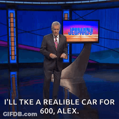 Man In Suit And Tie In Front Of Jeopardy Screen GIF