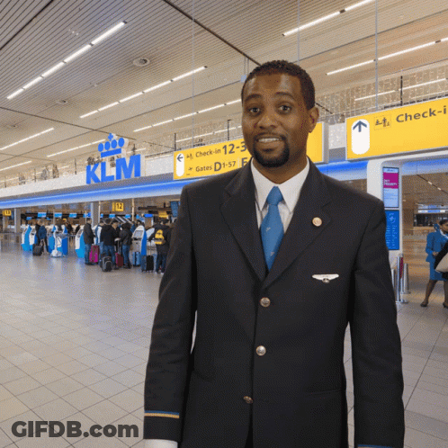 Man In Suit And Tie In Front Of KLM Sign GIF