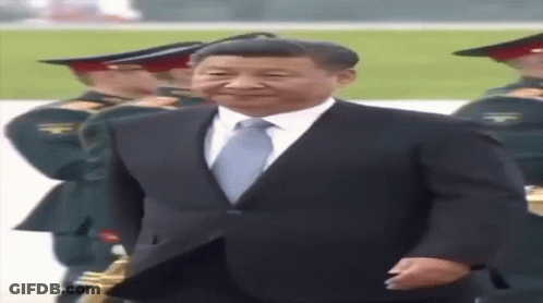 Man In Suit And Tie In Front Of Military Band GIF