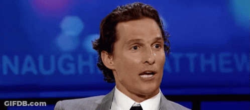 Man In Suit And Tie In Front Of Naught Sign GIF