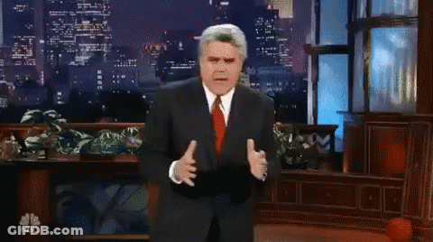 Man In Suit And Tie In Front Of NBC Logo GIF