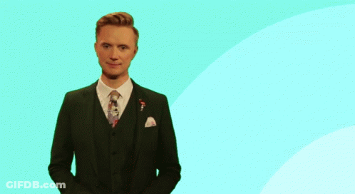 Man In Suit And Tie In Front Of Pink And Yellow Circle GIF