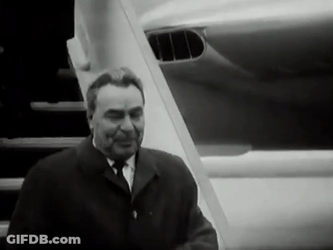 Man In Suit And Tie In Front Of Plane GIF