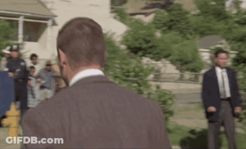 Man In Suit And Tie In Front Of Police Officers GIF