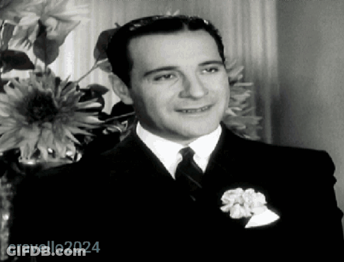 Man In Suit And Tie In Front Of Vase Of Flowers 2024 GIF