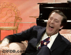 Man In Suit And Tie Laughing At Piano GIF