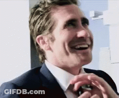 Man In Suit And Tie Laughing Hands In Pockets GIF