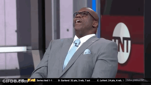Man In Suit And Tie Laughing In Front Of TNT Logo GIF