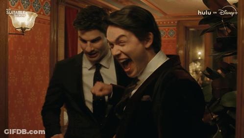 Man In Suit And Tie Laughing In Hallway Hulu On Disney+ GIF
