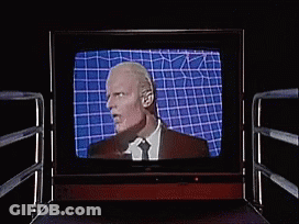 Man In Suit And Tie Laughing On TV GIF