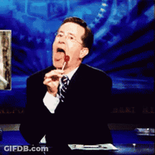 Man In Suit And Tie Licking Red Lollipop GIF