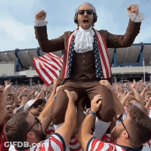 Man In Suit And Tie Lifted By Crowd GIF