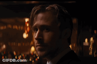 Man In Suit And Tie Looking At Camera In Dark Room GIF